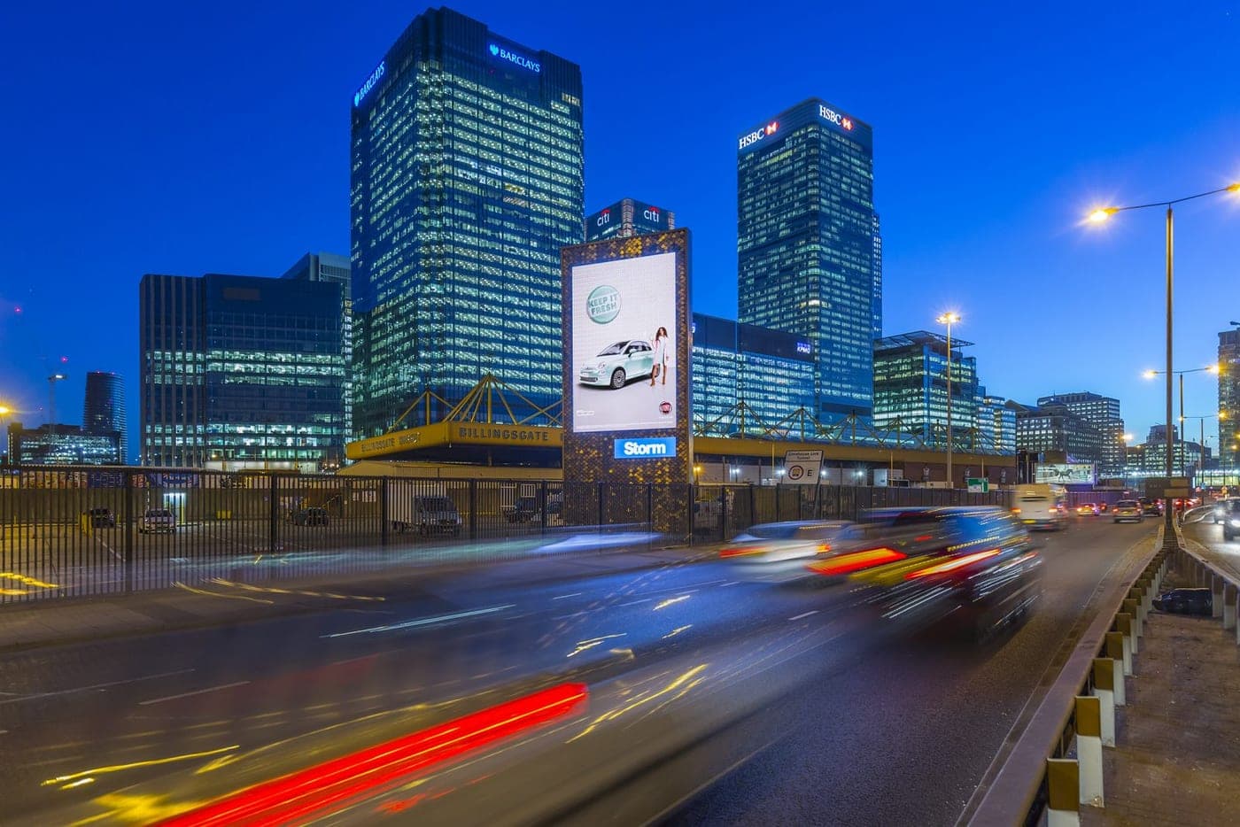 Digital 48-sheet billboard screen lit up beside a UK road at night