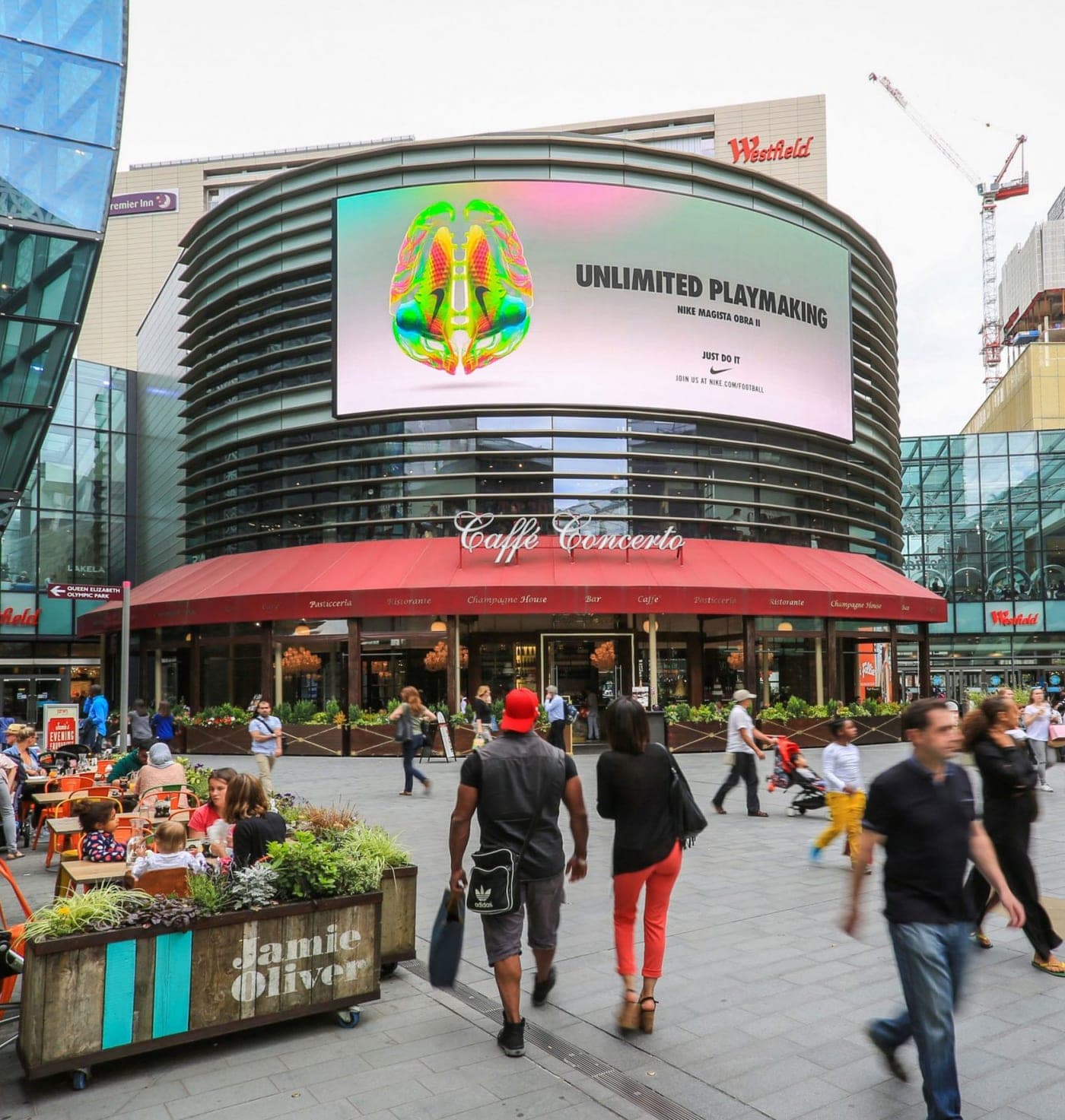 Curved digital billboard screen above a busy London shopping street