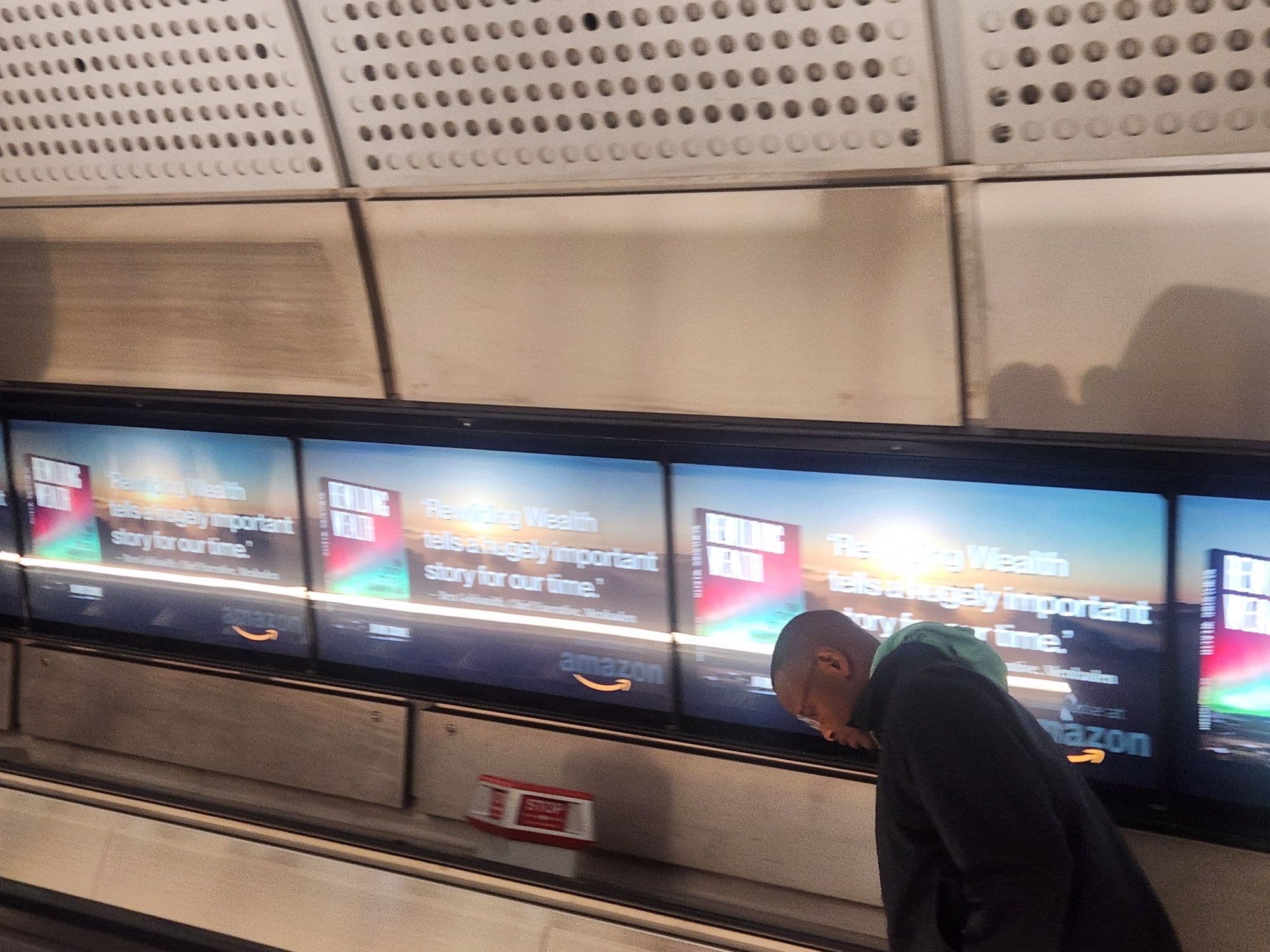 Farringdon digital ribbon panels running the Rewilding Wealth creative alongside the escalators