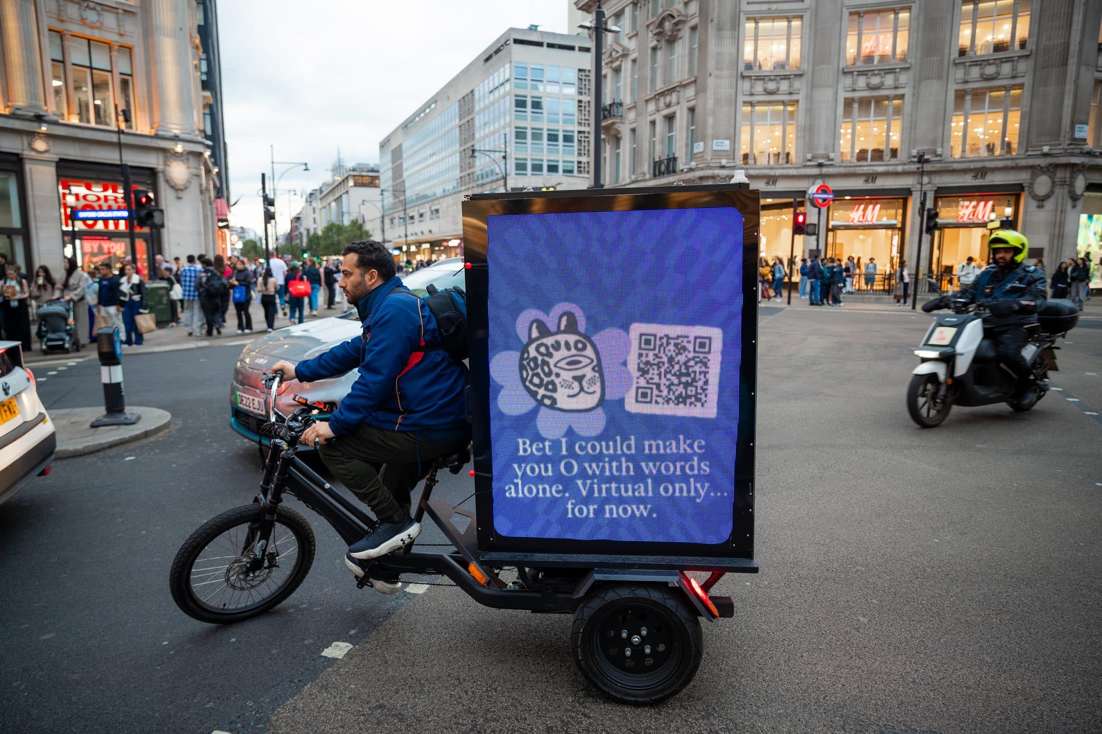 Pure AdBike crossing a central London junction as the lights come on