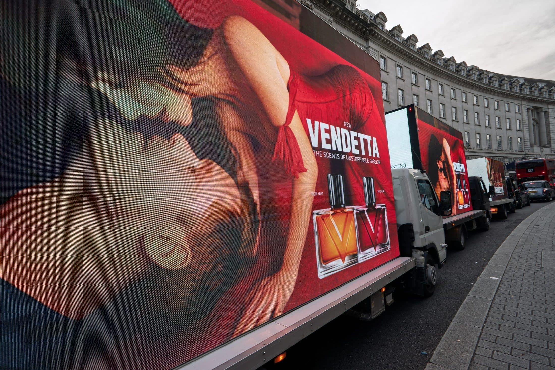 The Valentino Vendetta artwork filling the side of a Monster Digital AdVan on Regent Street in daylight, with two more vans in convoy behind