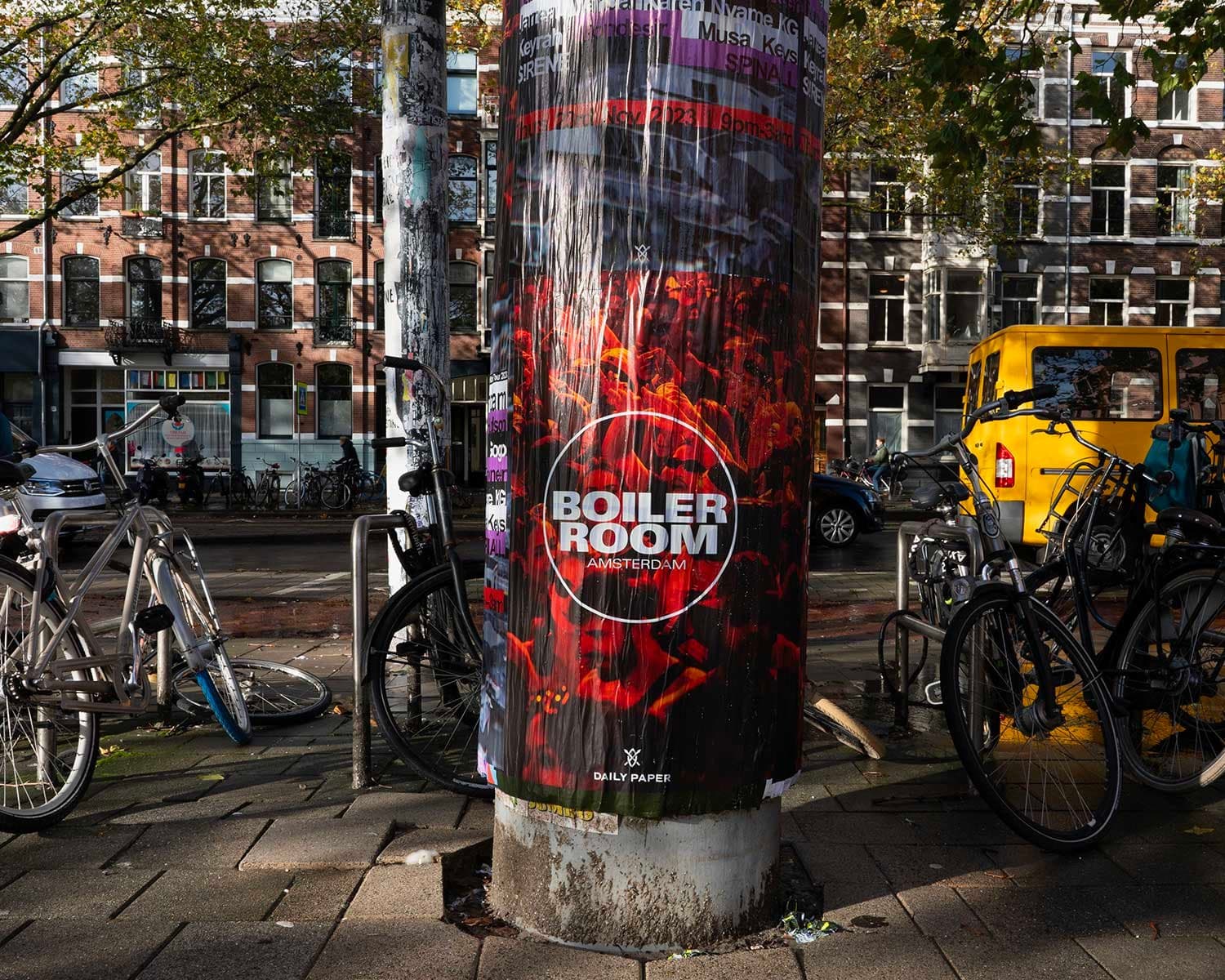 Street poster column glowing under city lights at night