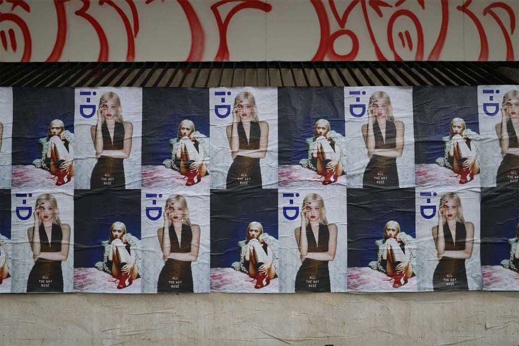 Dense grid of B2 flyposters on a street wall